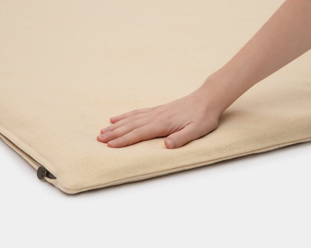 wool floor sleeping mat a hand pressing down