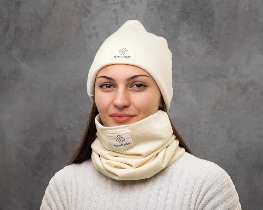 woman smiling and wearing nomad heat beanie and neck buff on grey background