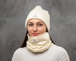 woman smiling and wearing nomad heat beanie and neck buff on grey background