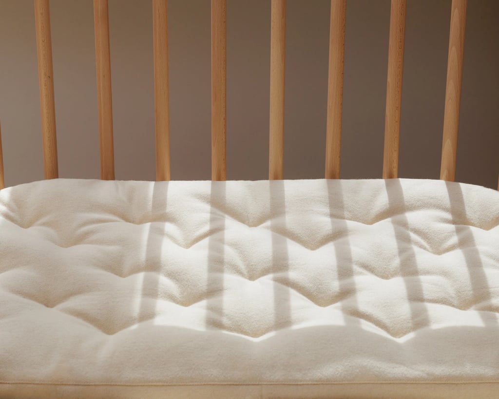 Profilbillede af et hjem med babybay-vugge i uld placeret på en tremmeseng