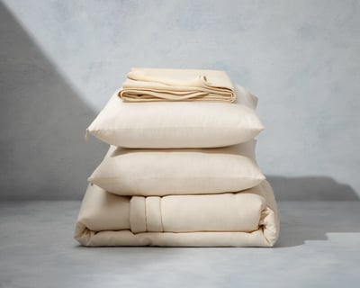 ulldyne, ulldynebeskytter og ullputepakke på grå bakgrunn