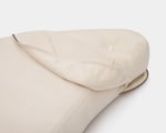 A heart-shaped wool pillow with a soft cotton cover in a light neutral color, designed for comfort with a simple, minimalist look.