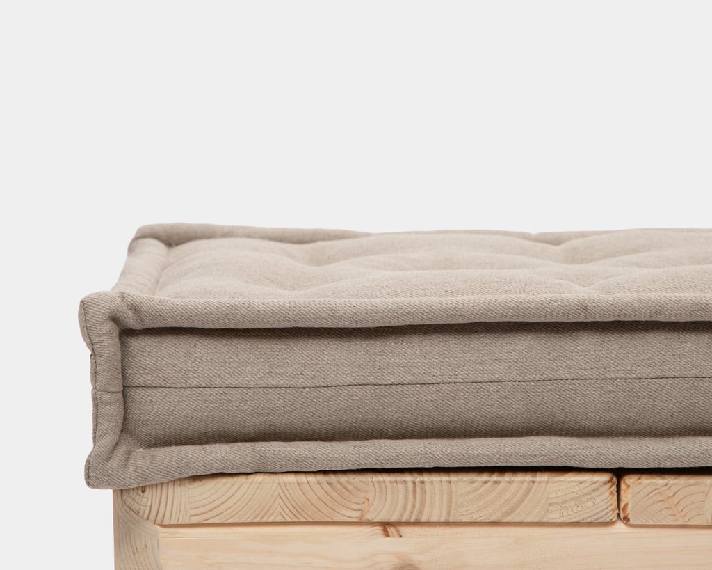 Beige tufted linen bench cushion on a wooden bench
