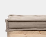 Beige tufted linen bench cushion on a wooden bench