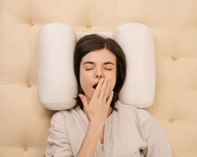 girl yawning on home of wool back sleeper pillow