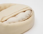 close up of the round wool dog bed with the cover and cushion inside