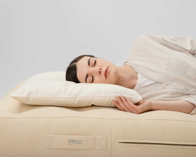 wool thin pillow with a woman sleeping on it, on her side
