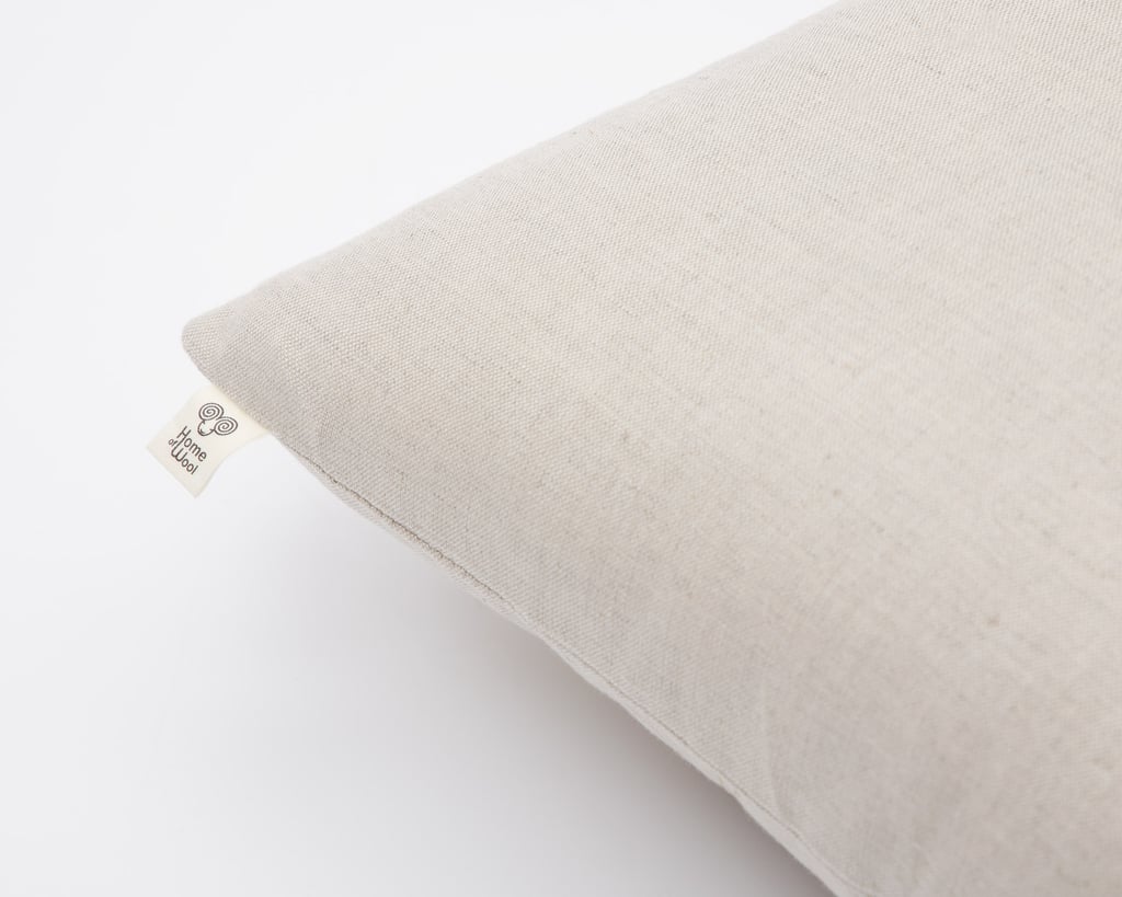 Detalje af Home of wool-kropspude med pudebetræk i hør