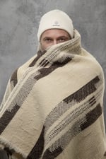 man wrapped in nomad heat heavy wool blanket
