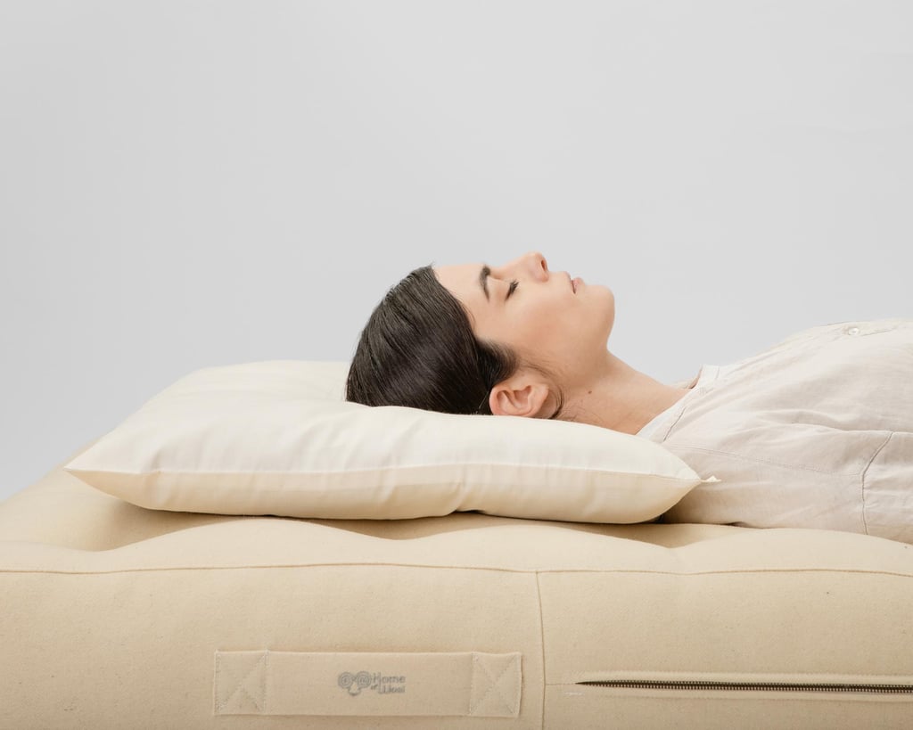 wool thin pillow with a woman sleeping on it, on her back