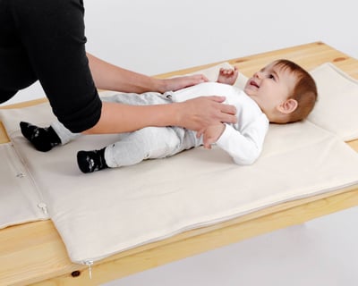 baby på bärbar skötbädd