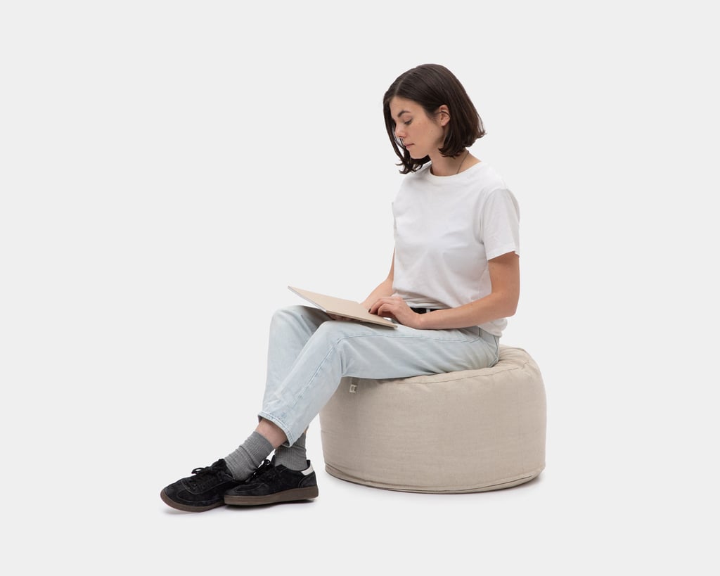 woman sitting on a woolen linen pouf