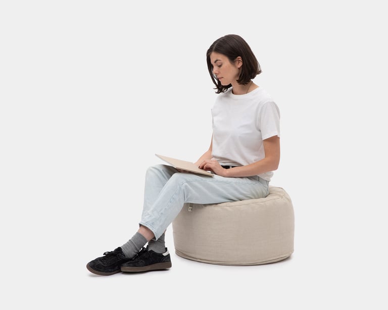 woman sitting on a woolen linen pouf