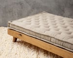 wool tufted seat cushion on a bed