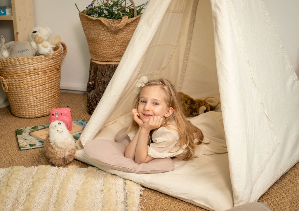 kids teepee tent in a childs room with a girl laying in it