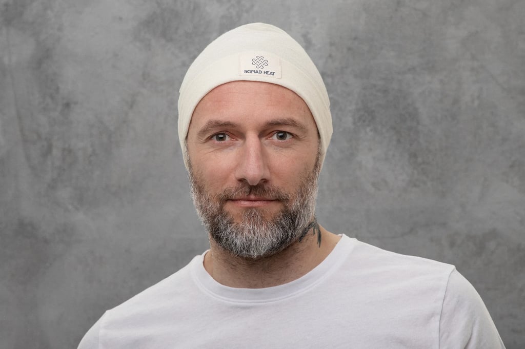 man with beard wearing nomad heat beanie on grey background