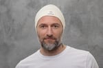 man with beard wearing nomad heat beanie on grey background