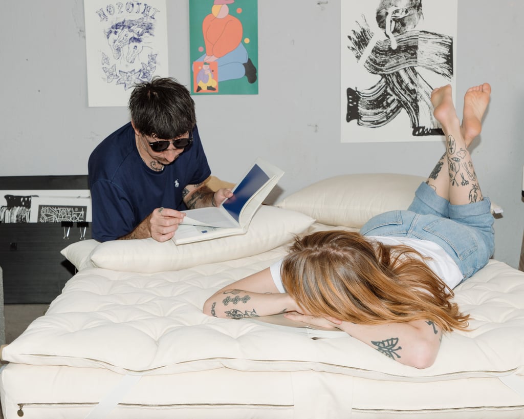 man reading on wool pillow on wool mattress with his girlfriend