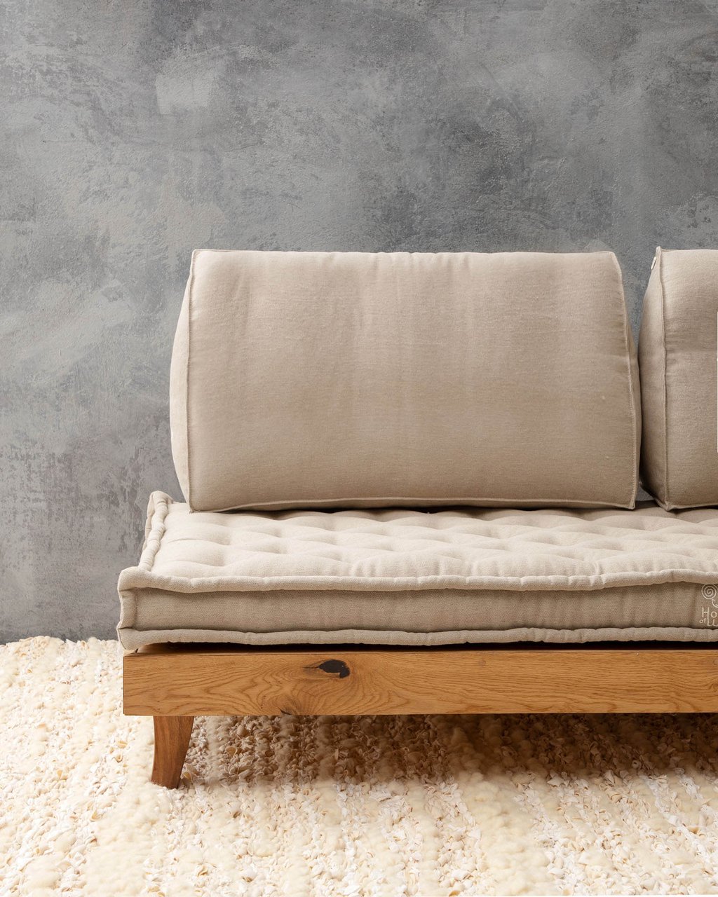 Dreieckiges Rückenkissen auf einem Sofa an einer Wand