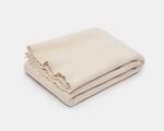 Couverture en pure laine vierge pliée sur fond blanc