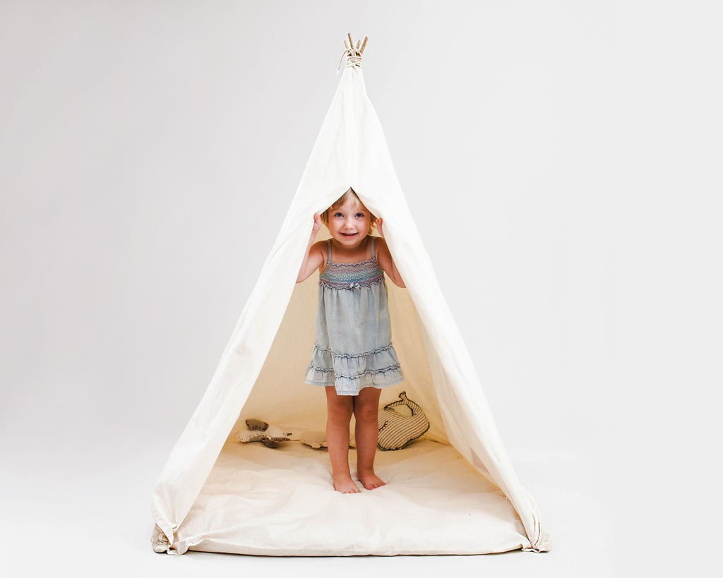 kids teepee tent in full view, wit the curtains open and a child inside