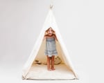 kids teepee tent in full view, wit the curtains open and a child inside