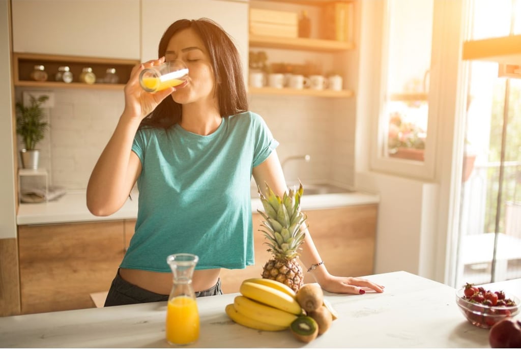 kvinne som drikker fersk juice om morgenen