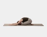 A girl is practicing yoga on a wool yoga mat