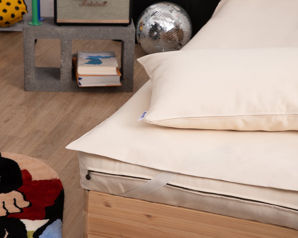 cotton mattress protector on mattress with pillow on top