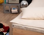 cotton mattress protector on mattress with pillow on top