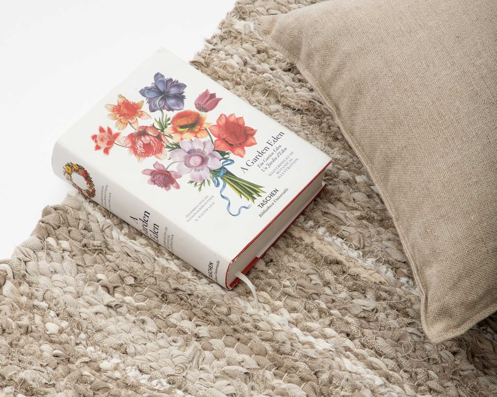 close up fabric handwoven linen area rug and book