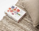 close up fabric handwoven linen area rug and book