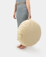 Donna che tiene un pouf ottomano in lana per il manico