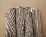 Four zero waste linen handwooven rugs on wooden wall