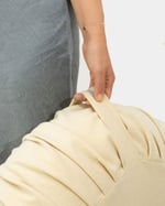 woman carrying wool ottoman pouf by the handle