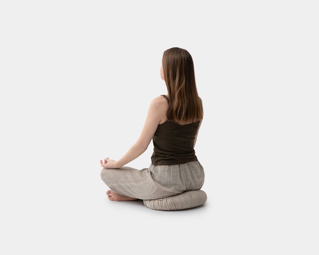 a girl sitting on a wool zafu yoga cushion