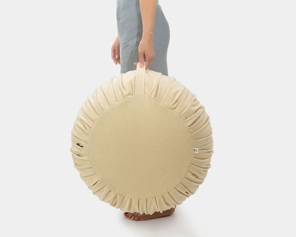 Donna che tiene un pouf ottomano in lana per il manico