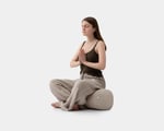 A girl is sitting on a yoga bolster