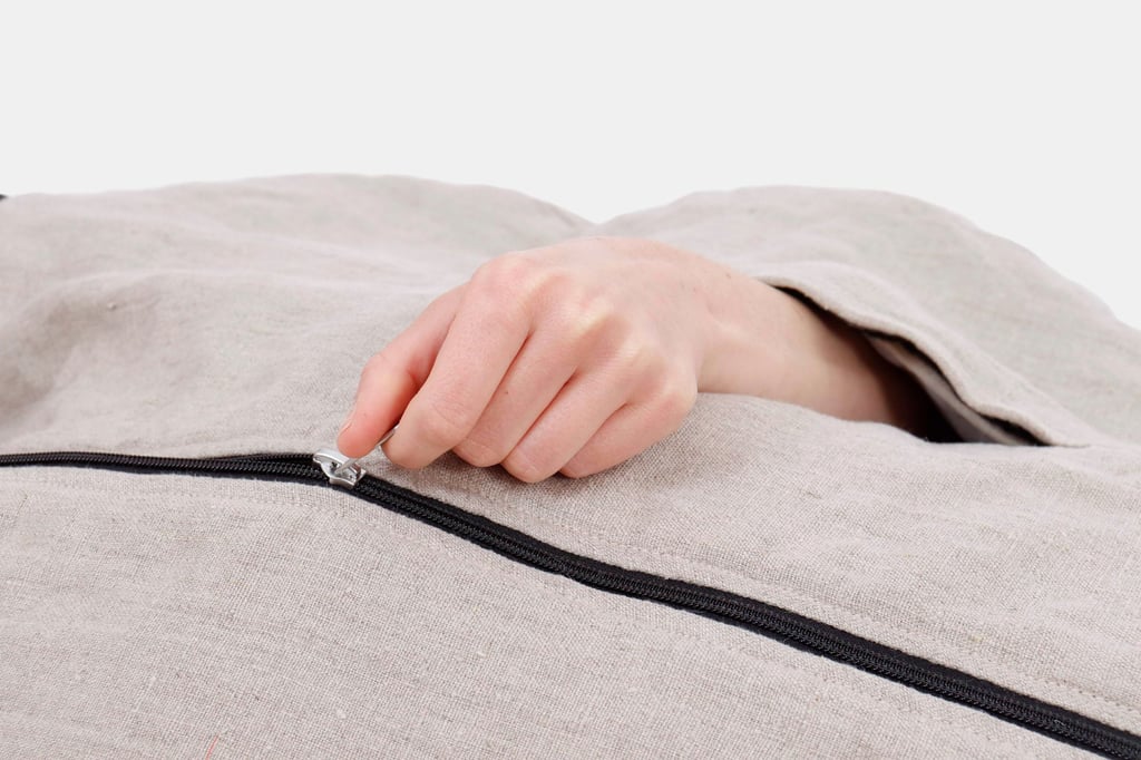 ullsovsäck närbild av hand som drar upp/ned dragkedjan