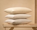 three wool pillows on a wooden background