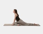 A girl is practicing yoga on a wool yoga mat