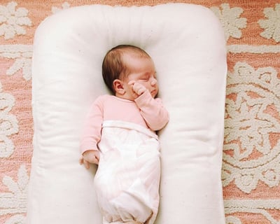 Baby wool lounger with a baby sleeping in it
