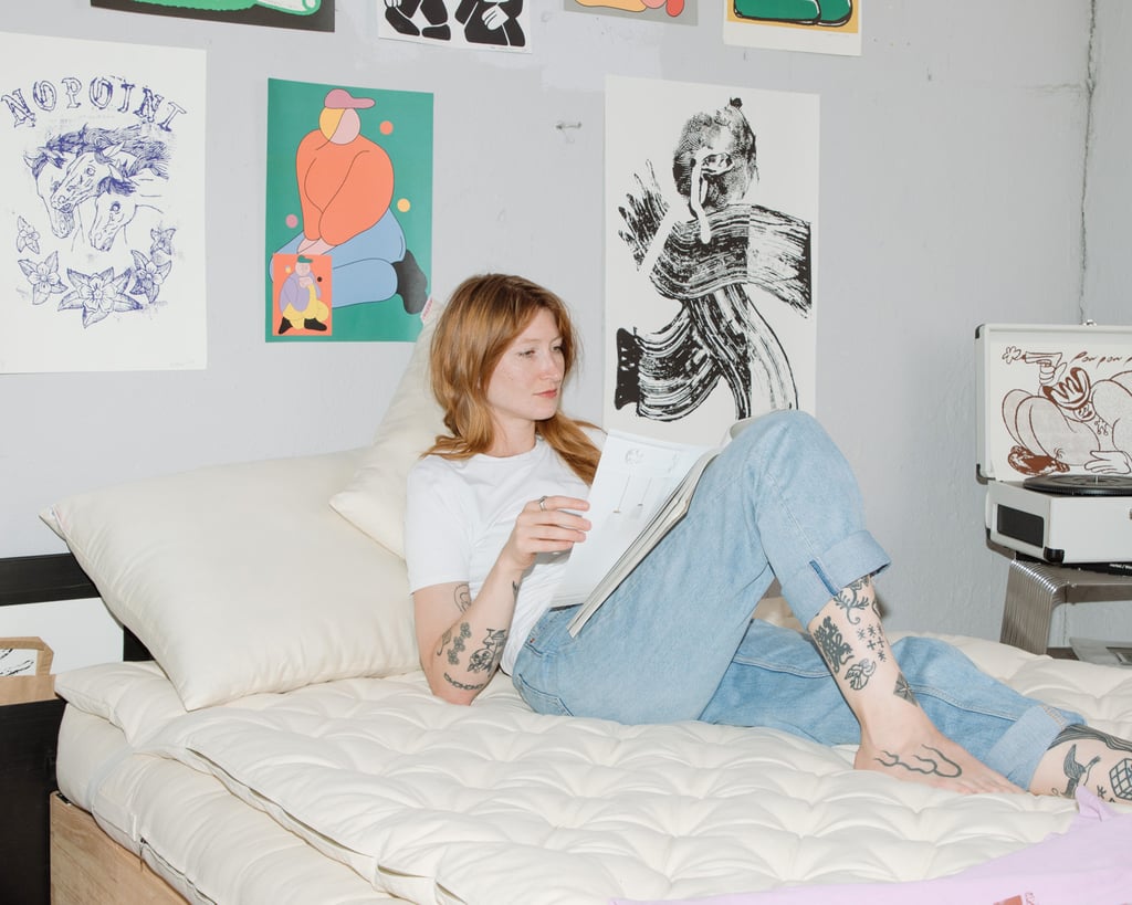 Girl laying on wool pillow on wool mattress reading a book