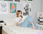 Girl laying on wool pillow on wool mattress reading a book