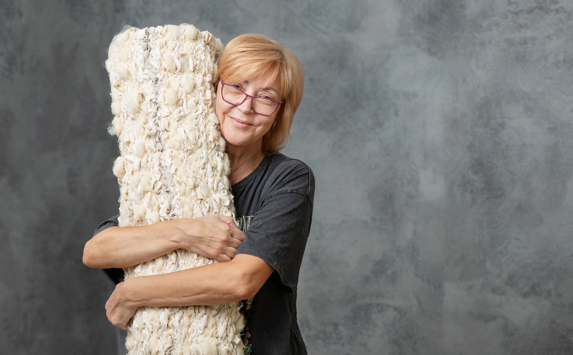 een vrouw die een zero-waste tapijt knuffelt