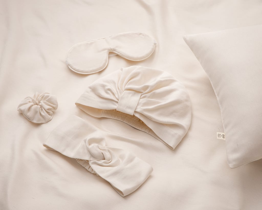 Schlafmaske, Turban, Haargummi und Haarband auf Seidenunterlage