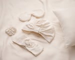 Schlafmaske, Turban, Haargummi und Haarband auf Seidenunterlage