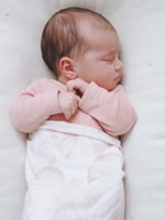 baby sleeping in a wool baby lounger