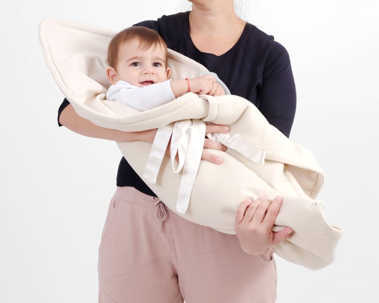 mom holding baby covered with home of wool saddle blanket