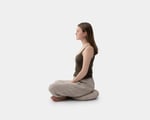 a girl sitting on a wool zafu yoga cushion
